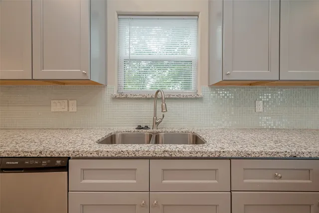 a kitchen with granite countertop cabinets sink and window