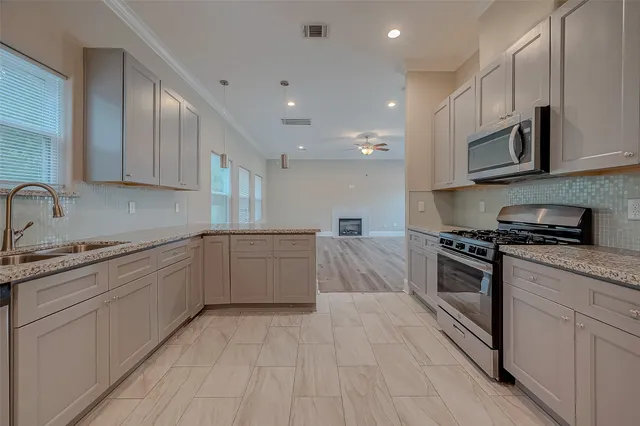 a large kitchen with stainless steel appliances granite countertop a stove and a sink