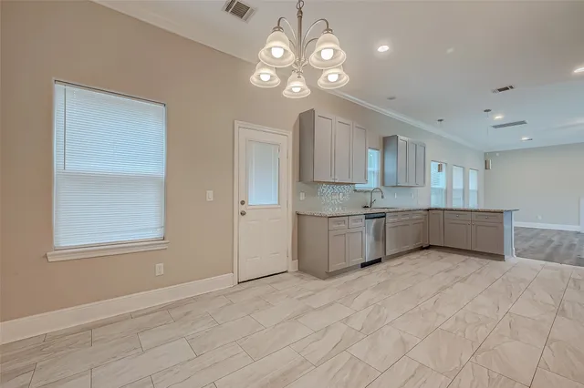 a large white kitchen with kitchen island a sink stainless steel appliances and cabinets