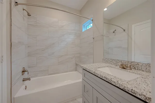 a bathroom with a granite countertop sink a toilet and bathtub