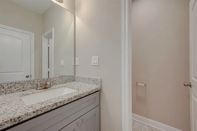 a bathroom with a granite countertop sink and mirror