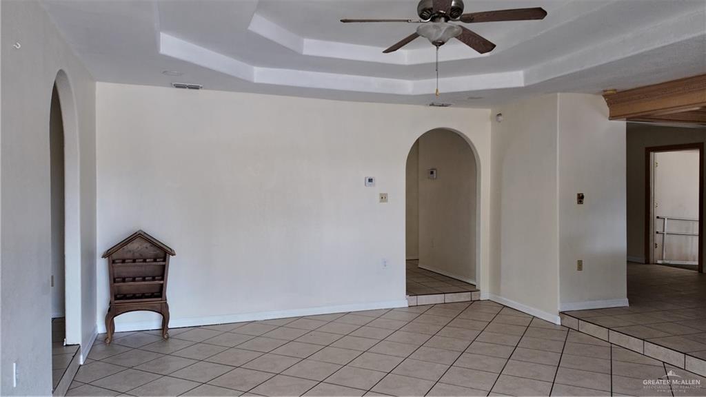 612 West Ramirez Street Rio Grande City, TX 78582 - Photo 14 of 40 Spare room with arched walkways, ceiling fan, light tile patterned floors, and a raised ceiling