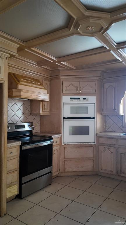 612 West Ramirez Street Rio Grande City, TX 78582 - Photo 18 of 40 Kitchen with stainless steel range with electric stovetop, custom range hood, light tile patterned floors, tasteful backsplash, and white double oven