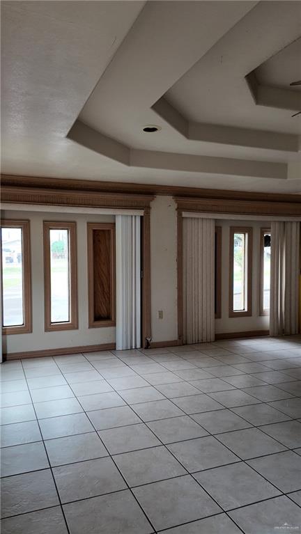612 West Ramirez Street Rio Grande City, TX 78582 - Photo 22 of 40 Empty room featuring a raised ceiling, light tile patterned floors, and healthy amount of natural light