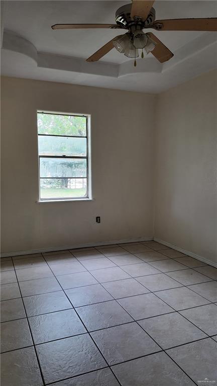 612 West Ramirez Street Rio Grande City, TX 78582 - Photo 34 of 40 Spare room featuring light tile patterned floors, a tray ceiling, and a ceiling fan