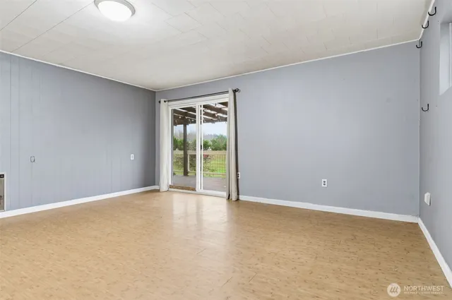 an empty room with sliding door and wooden floor