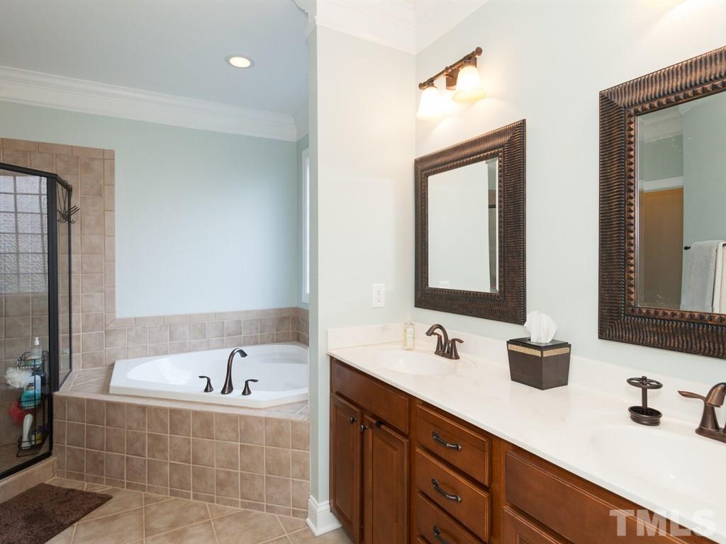 201 Challenge Road Raleigh, NC 27603 - Photo 12 of 25 a bathroom with a bathtub double sink and mirror