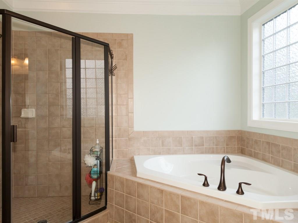 201 Challenge Road Raleigh, NC 27603 - Photo 13 of 25 a bathroom with a bathtub and a shower