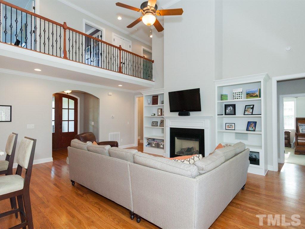 201 Challenge Road Raleigh, NC 27603 - Photo 6 of 25 a living room with furniture a fireplace and a flat screen tv