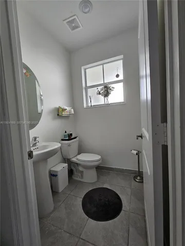 a bathroom with a toilet a sink and mirror