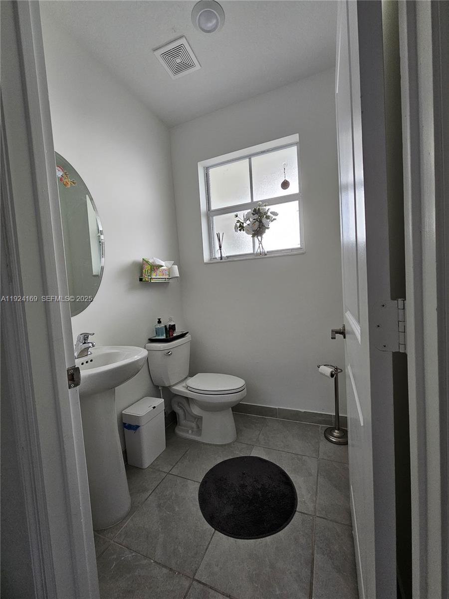 2637 Southeast 17th Street Homestead, FL 33035 - Photo 9 of 23 a bathroom with a toilet a sink and mirror