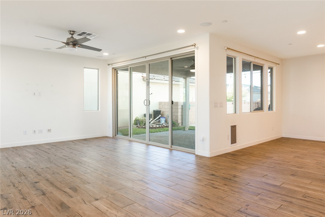 920 East Sunset Road Henderson, NV 89011 - Photo 5 of 33 Hardwood floors and a wide sliding glass door define this airy living space.