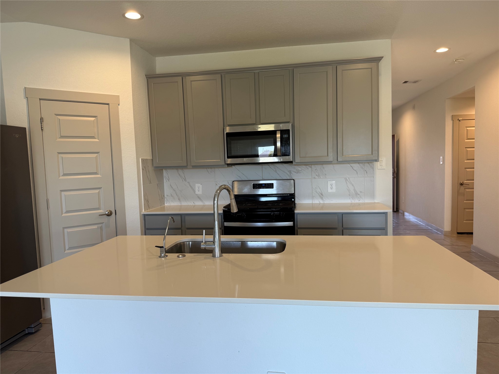 30007 Reagans Rnch Drive Katy, TX 77494 - Photo 18 of 23 a kitchen with a sink a microwave and cabinets