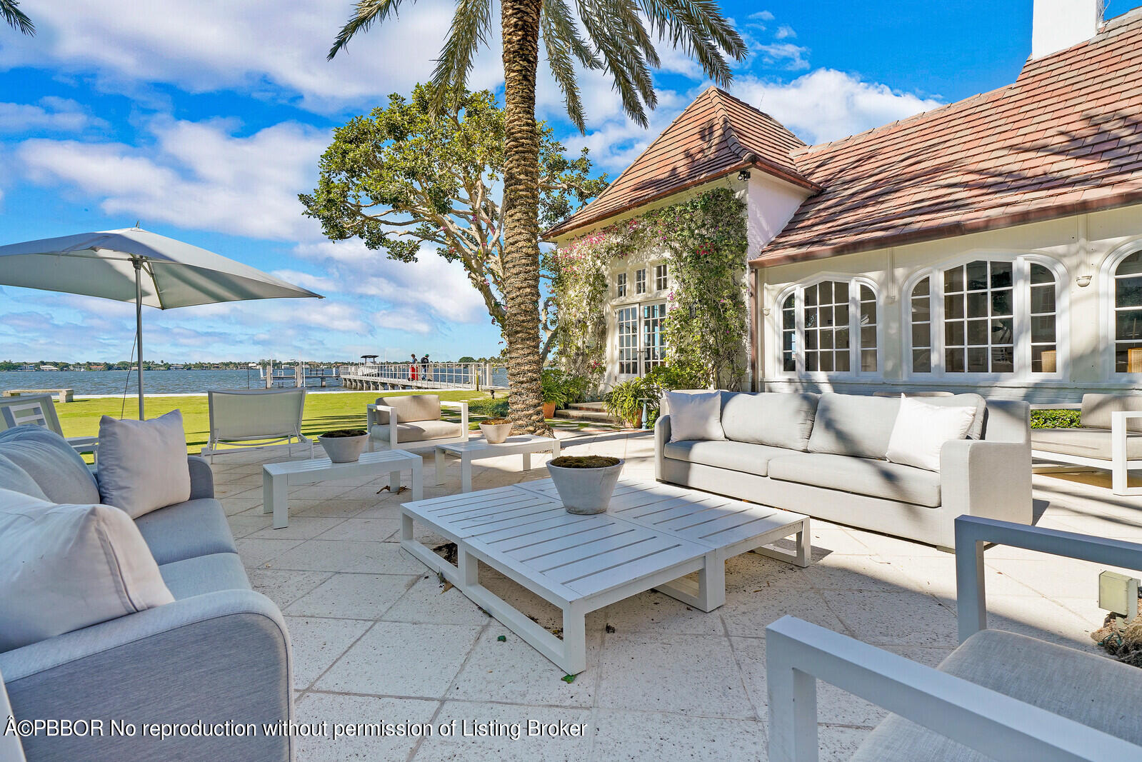 210 Via Del Mar Palm Beach, FL 33480 - Photo 78 of 85 a view of a patio with couches and a table and chairs under an umbrella