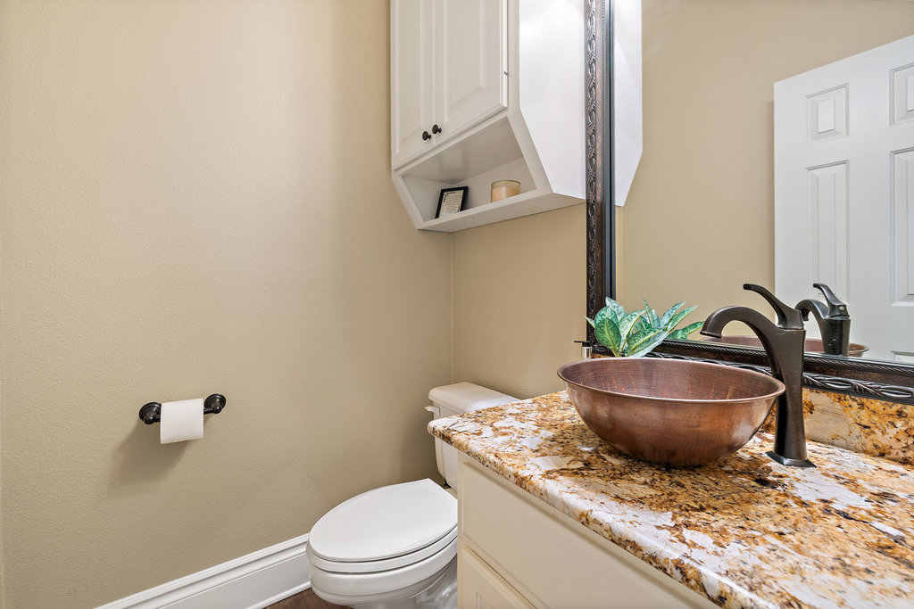 3507 Bee Creek Road Spicewood, TX 78669 - Photo 25 of 40 a bathroom with a granite countertop toilet and a mirror