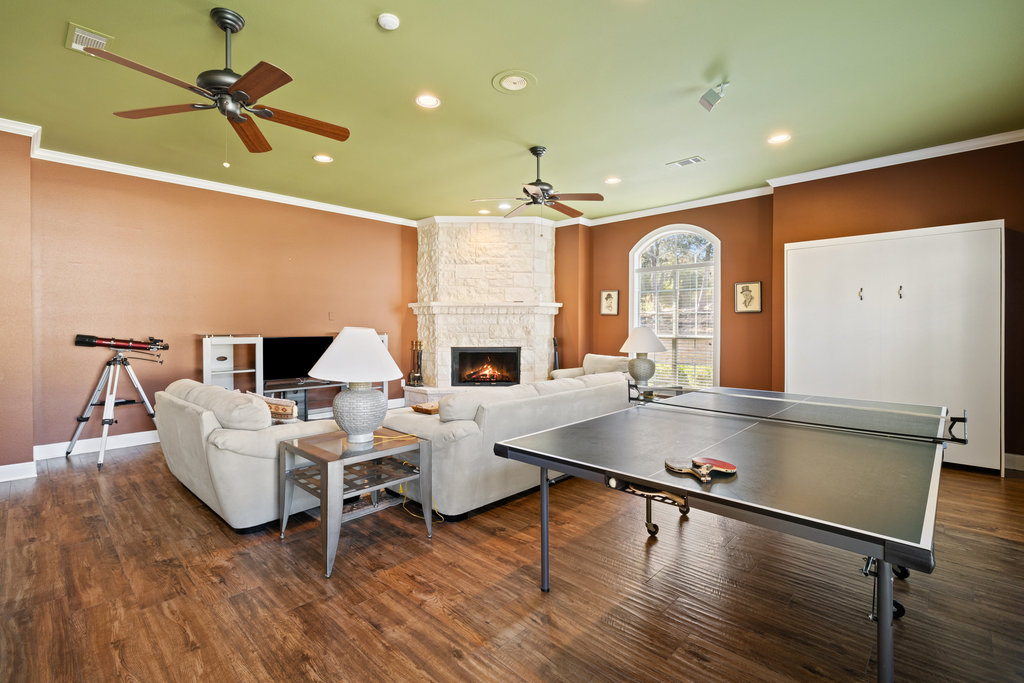 3507 Bee Creek Road Spicewood, TX 78669 - Photo 30 of 40 a living room with furniture pool table wooden floor and a ceiling fan