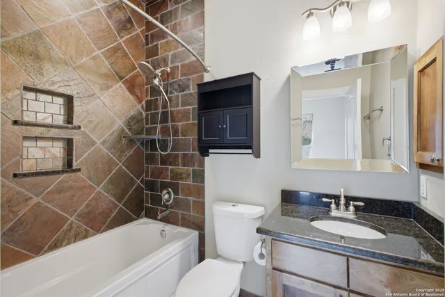a bathroom with a granite countertop sink toilet and shower