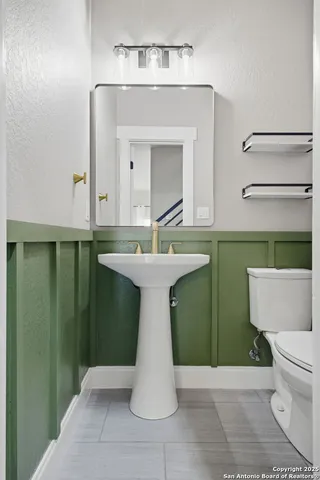 a bathroom with a sink toilet and mirror