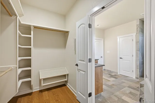 a view of walk in closet with empty racks