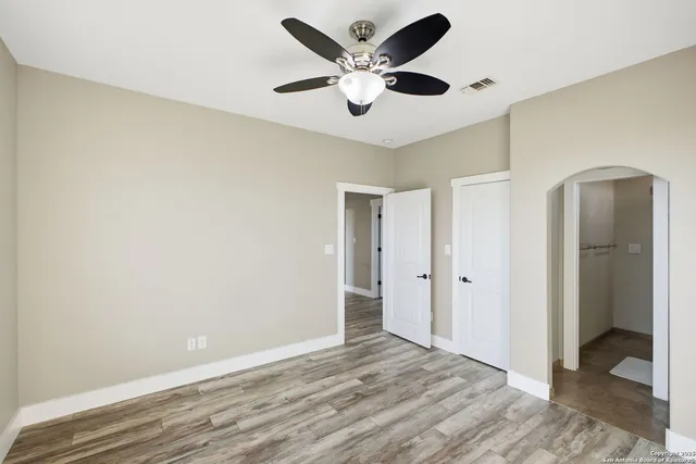 a view of an empty room with wooden floor