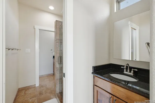 a bathroom with a granite countertop sink and a mirror
