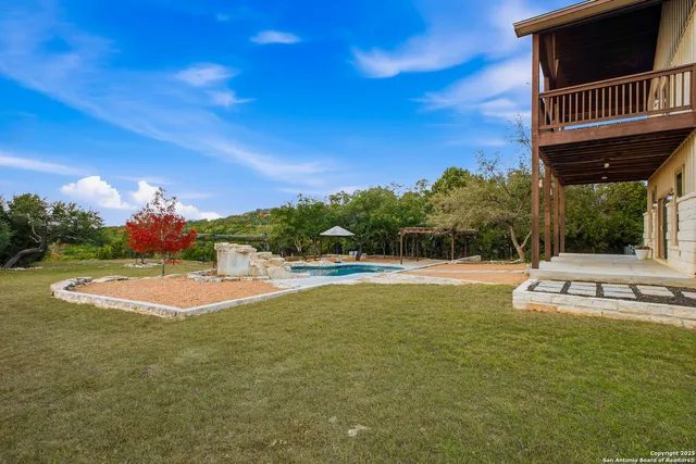 a view of a house with swimming pool and a yard