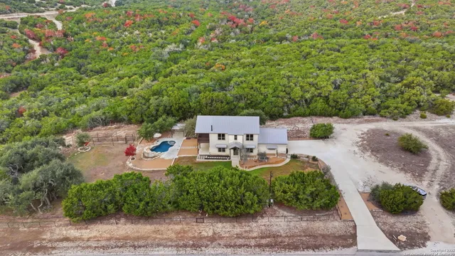 an aerial view of a house with outdoor space patio and trees all around