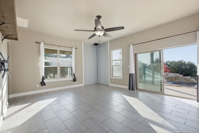 a view of an empty room with window chandelier
