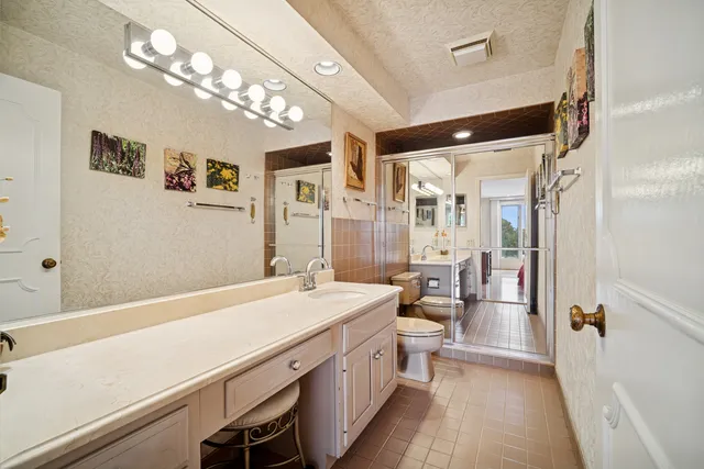 a bathroom with a sink a large mirror and a shower