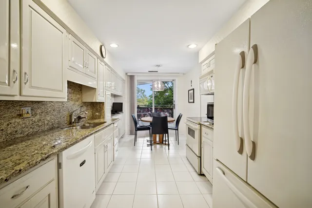 a kitchen with white cabinets and white appliances