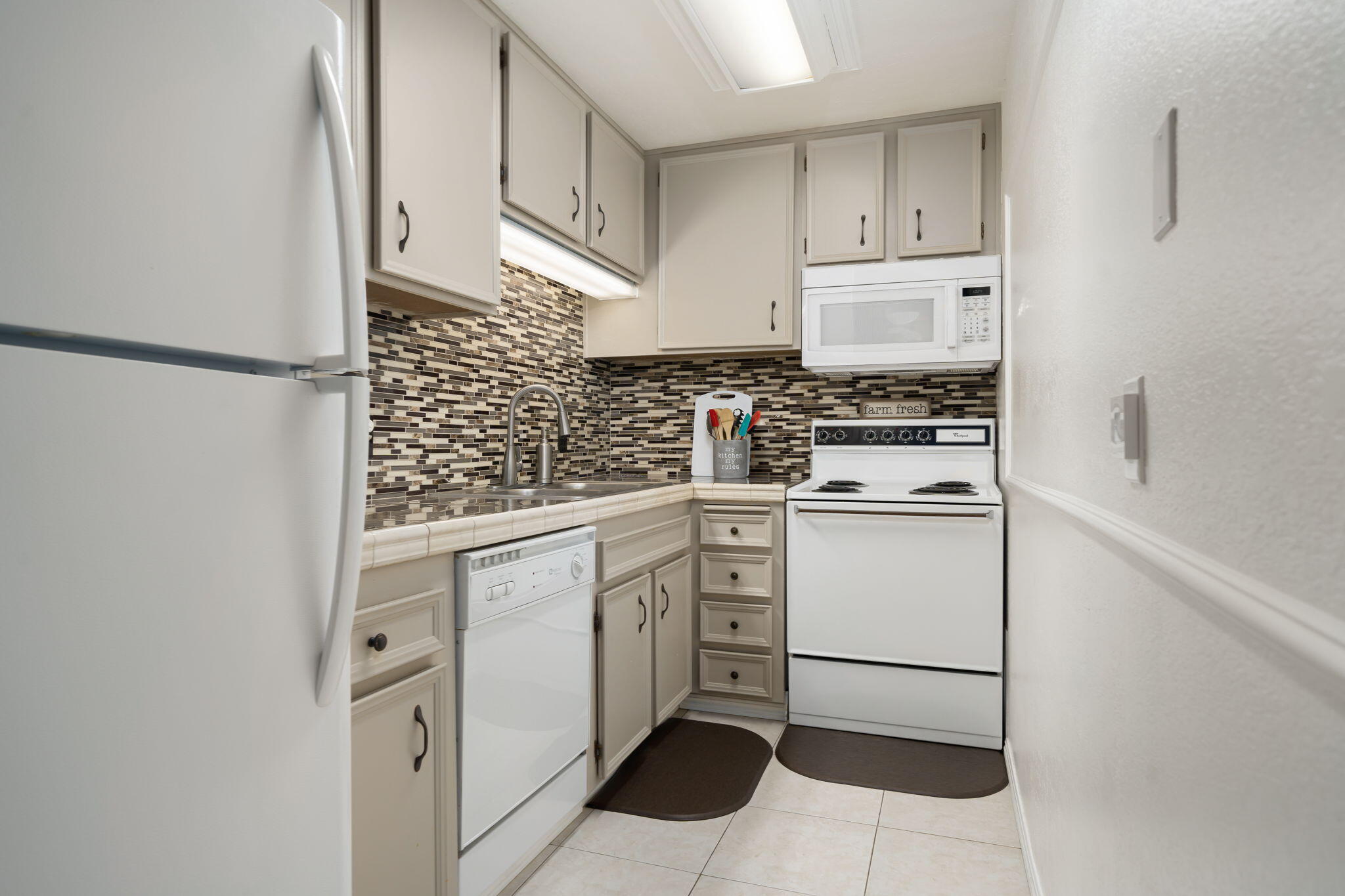 2860 North Los Felices Road, Unit 214 Palm Springs, CA 92262 - Photo 13 of 26 a kitchen with white cabinets and white appliances