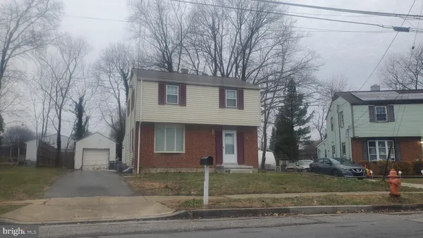 a front view of a house with garage and trees