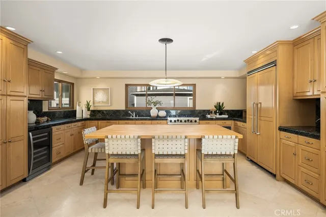 a kitchen with kitchen island granite countertop a counter space dining table and stainless steel appliances