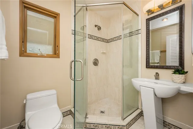 a bathroom with a toilet sink shower and mirror