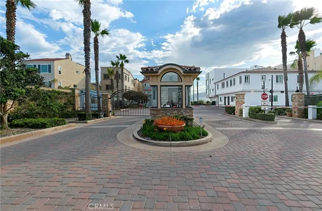 a front view of a building with garden and trees