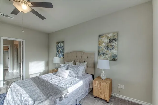 a spacious bedroom with a bed a couch and potted plant
