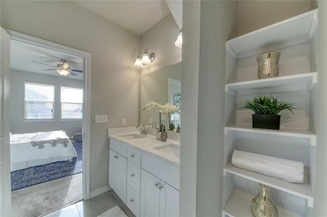 a bathroom with a double vanity sink mirror and next to a white cabinet