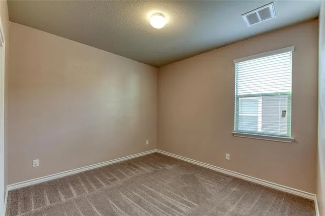 an empty room with a ceiling fan and a window