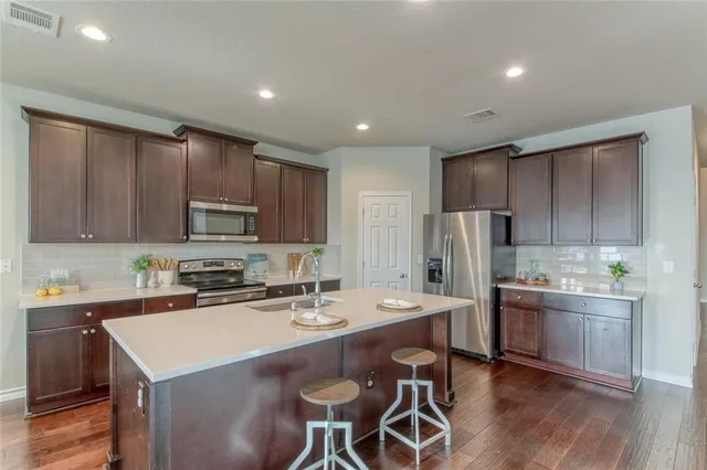 a large open kitchen with a large window and stainless steel appliances