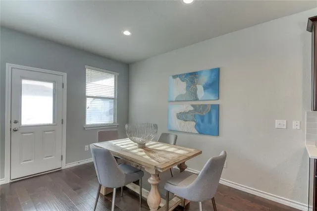 a living room with furniture dining table wooden floor and a large window