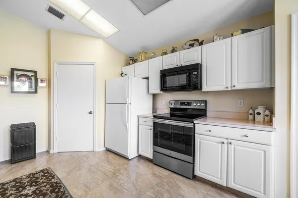 a kitchen with stainless steel appliances white cabinets a stove top oven a sink and dishwasher
