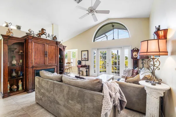 a living room with furniture a fireplace and a chandelier