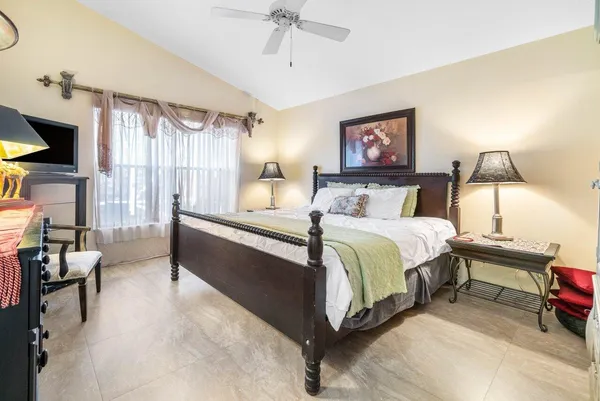 a spacious bedroom with a bed a couch and a chandelier