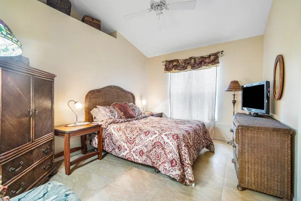 a bedroom with a bed and a flat tv screen on dresser