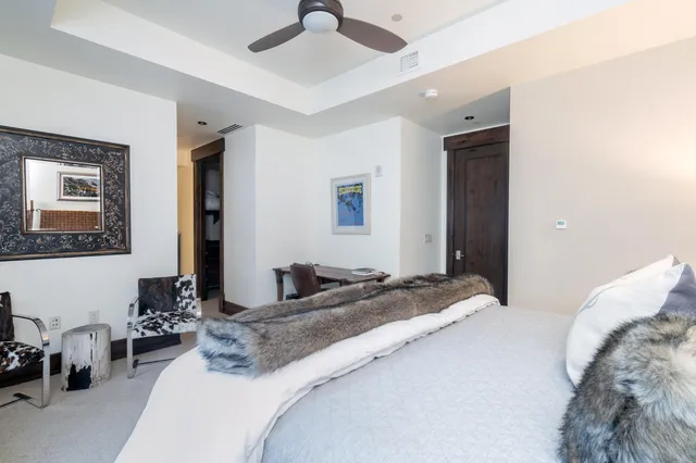 a bedroom with a large bed and a chandelier