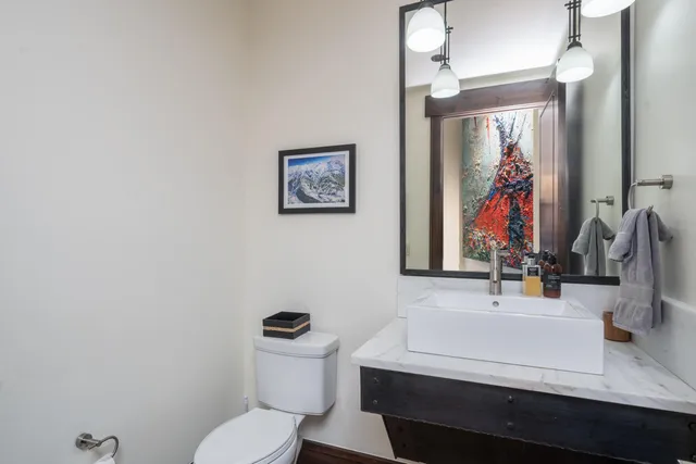 a bathroom with a sink a toilet and mirror