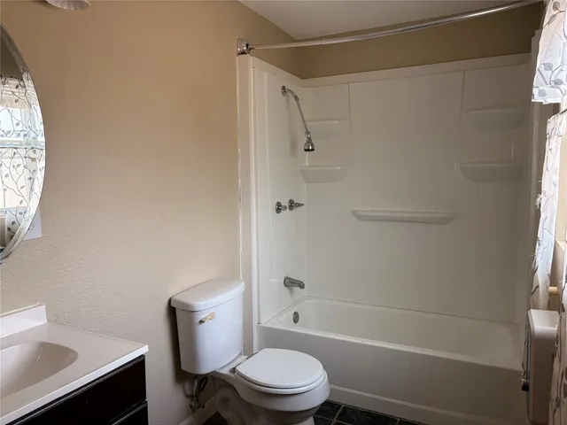 a white toilet and tub next to a window