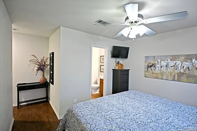 a bedroom with a bed and a flat tv screen on dresser