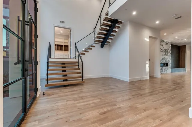 an empty room with wooden floor and stairs