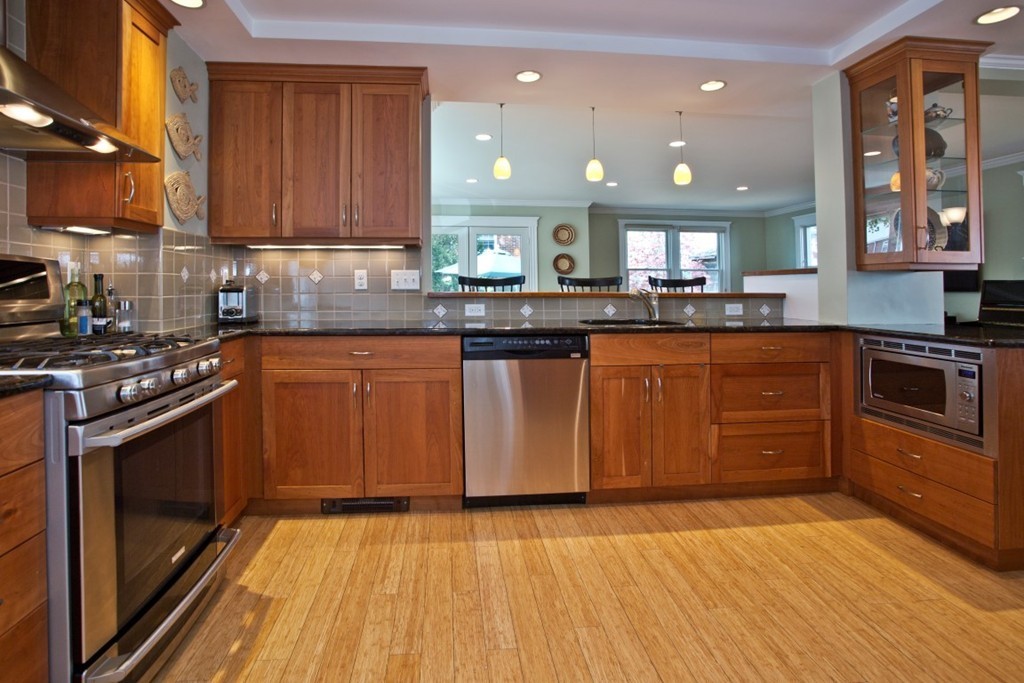 11 Brattle Place Arlington, MA 02474 - Photo 3 of 30 a kitchen with stainless steel appliances granite countertop a stove a sink dishwasher and a microwave oven with wooden floor